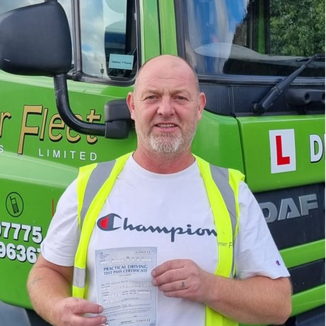 Man holding pass cerificate for HGV Driver Training Category C+E with PFS Training